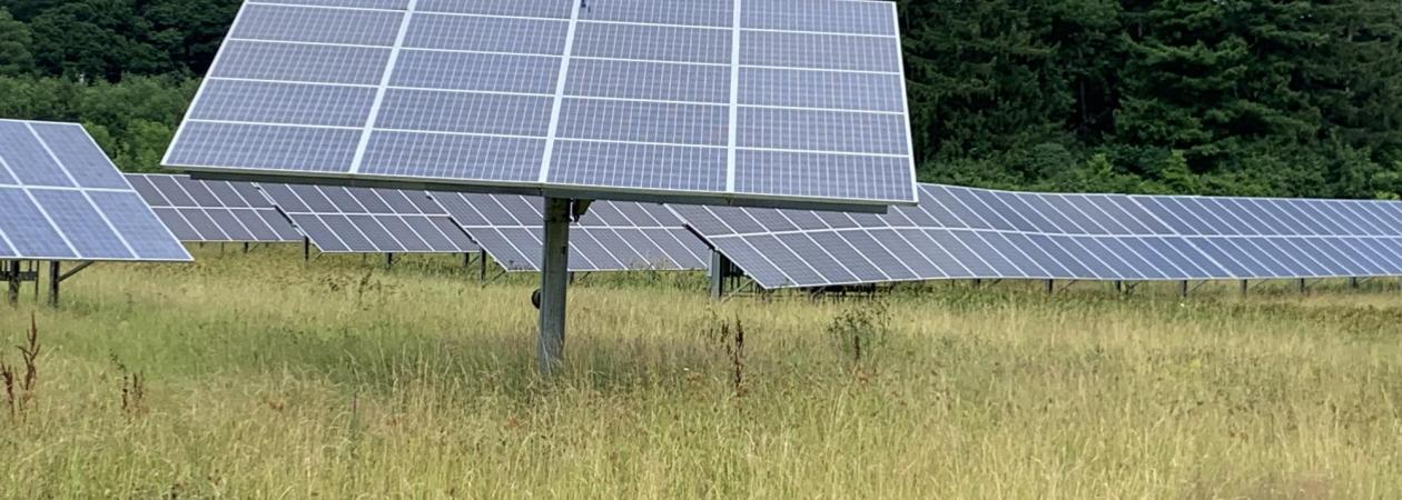 This image shows a solar panel in a grassy field. 